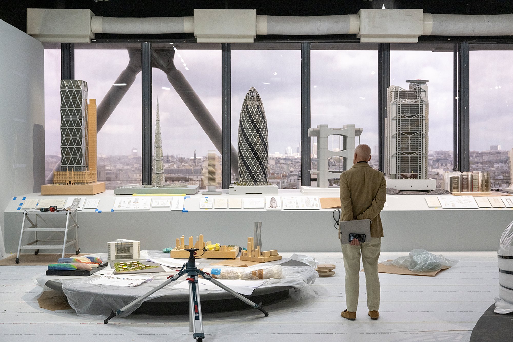 Norman Foster standing back to view 'The Vertical City' models, including Hearst Tower, Millennium Tower, 30 St Mary Axe and Hongkong and Shanghai Bank Headquarters (left to right).